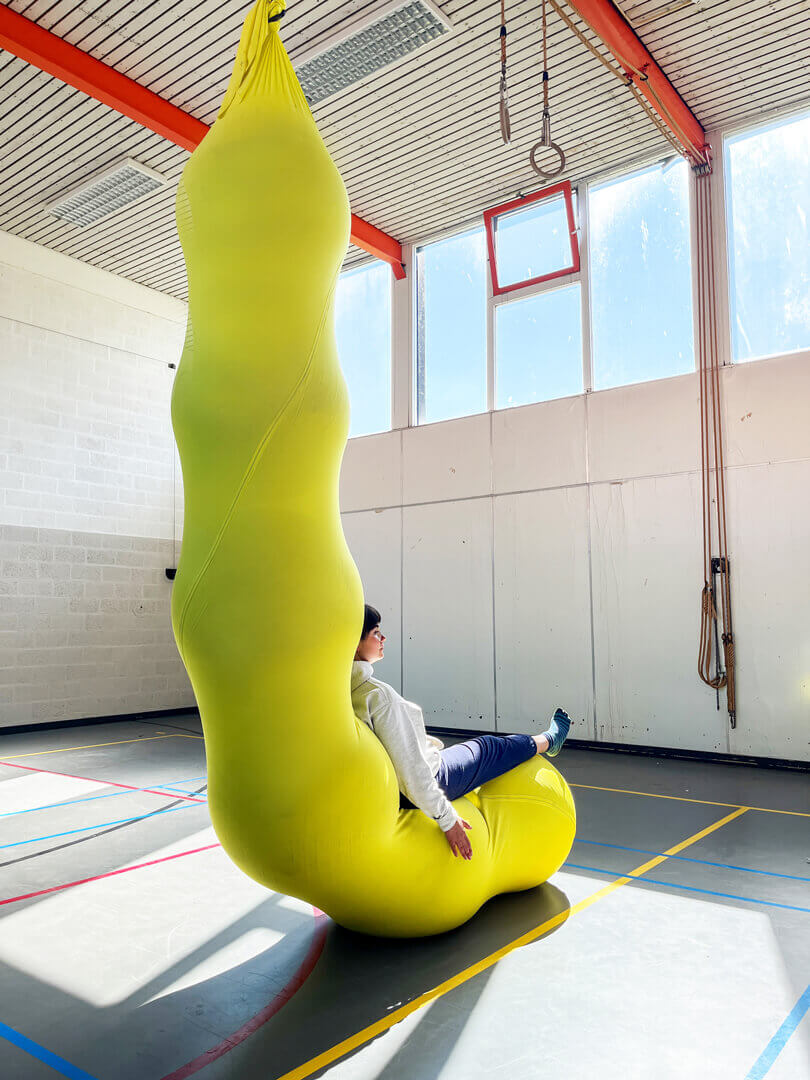 The LARVA is made from a massive sleeve of aerial silk fabric and filled with yoga balls to create a caterpillar-like structure.