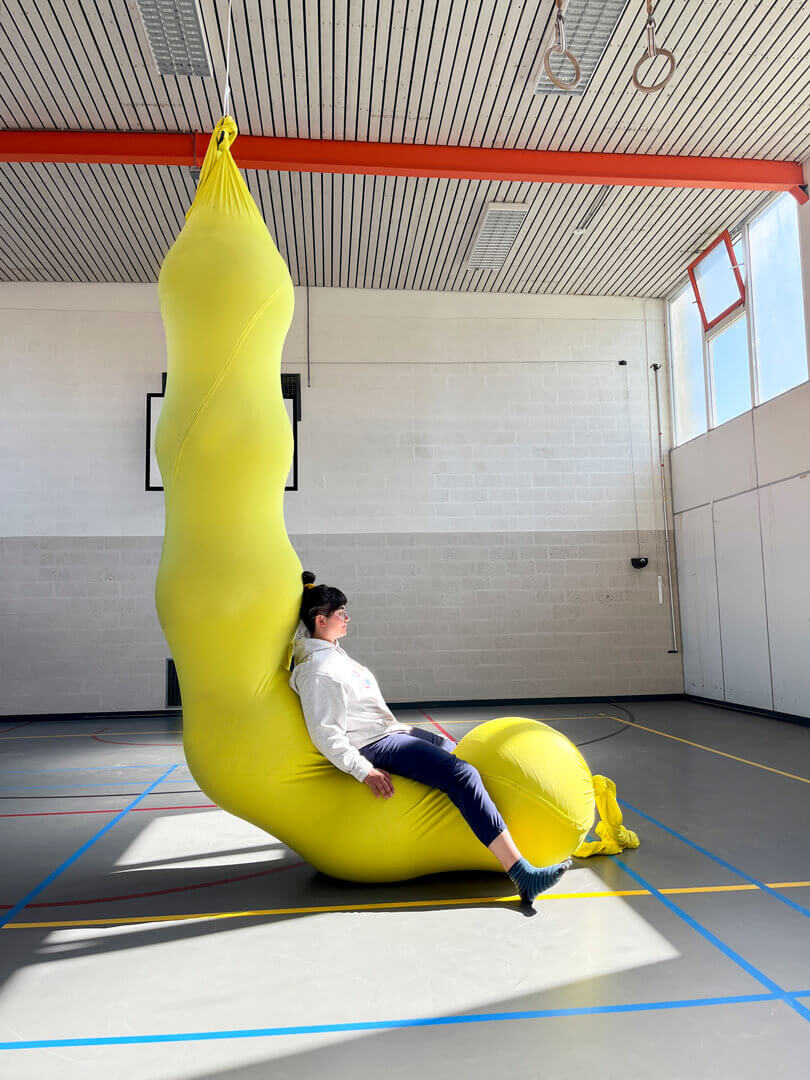 The LARVA is made from a massive sleeve of aerial silk fabric and filled with yoga balls to create a caterpillar-like structure.